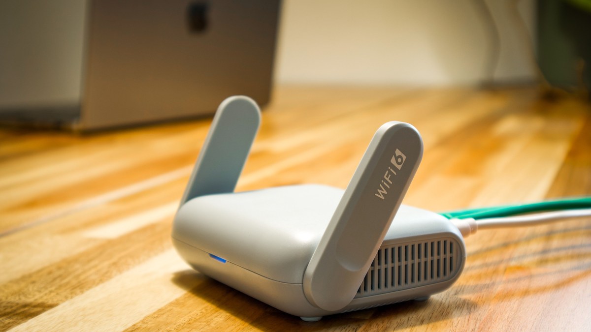 Wi-Fi router on a desk beside a laptop for home internet setup