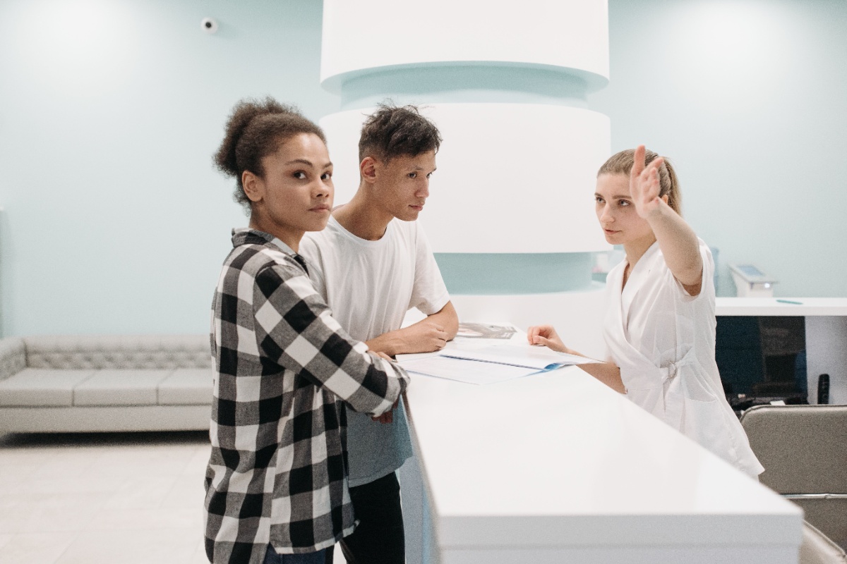 Patients checking in at a clinic reception counter