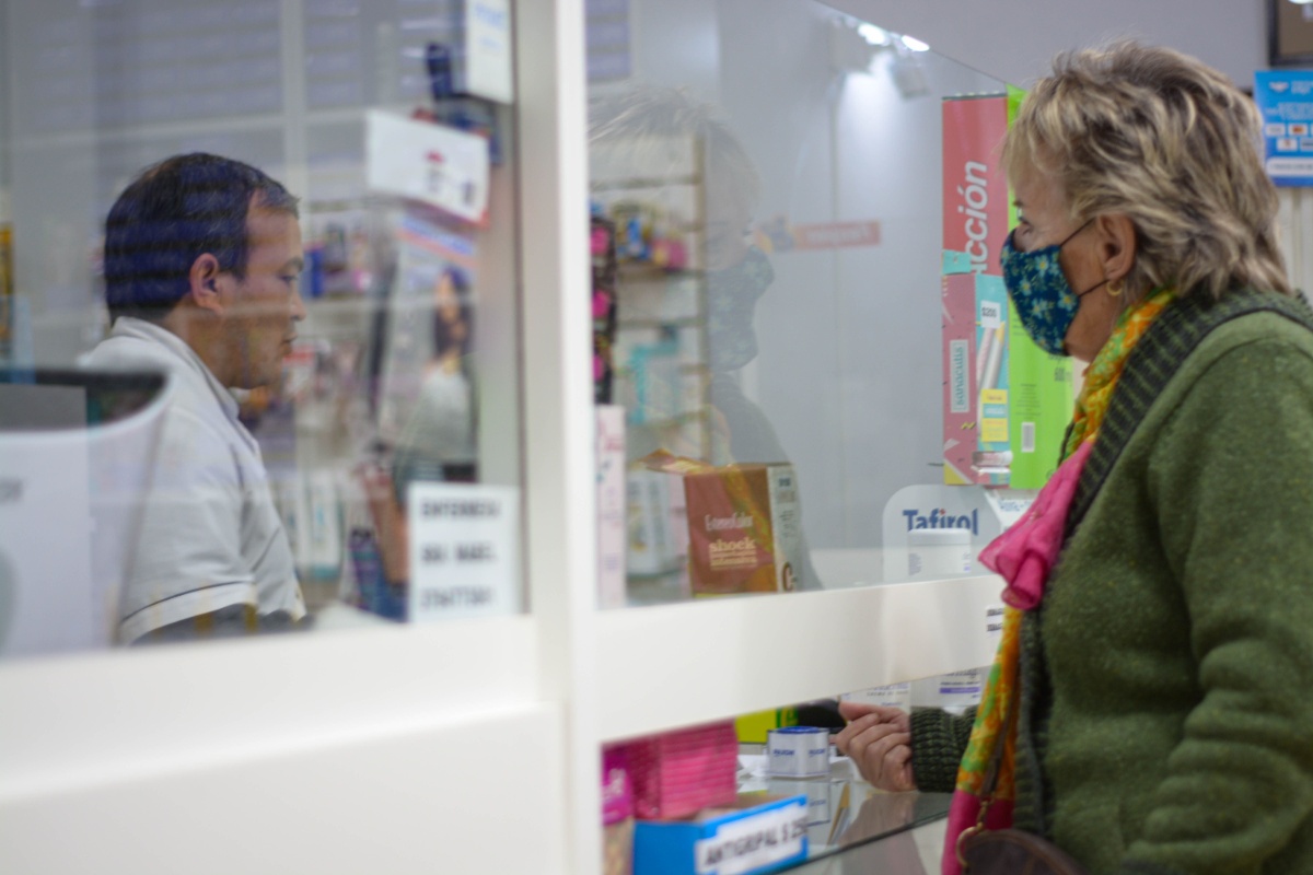 Patient speaking with a pharmacist at a pharmacy counter