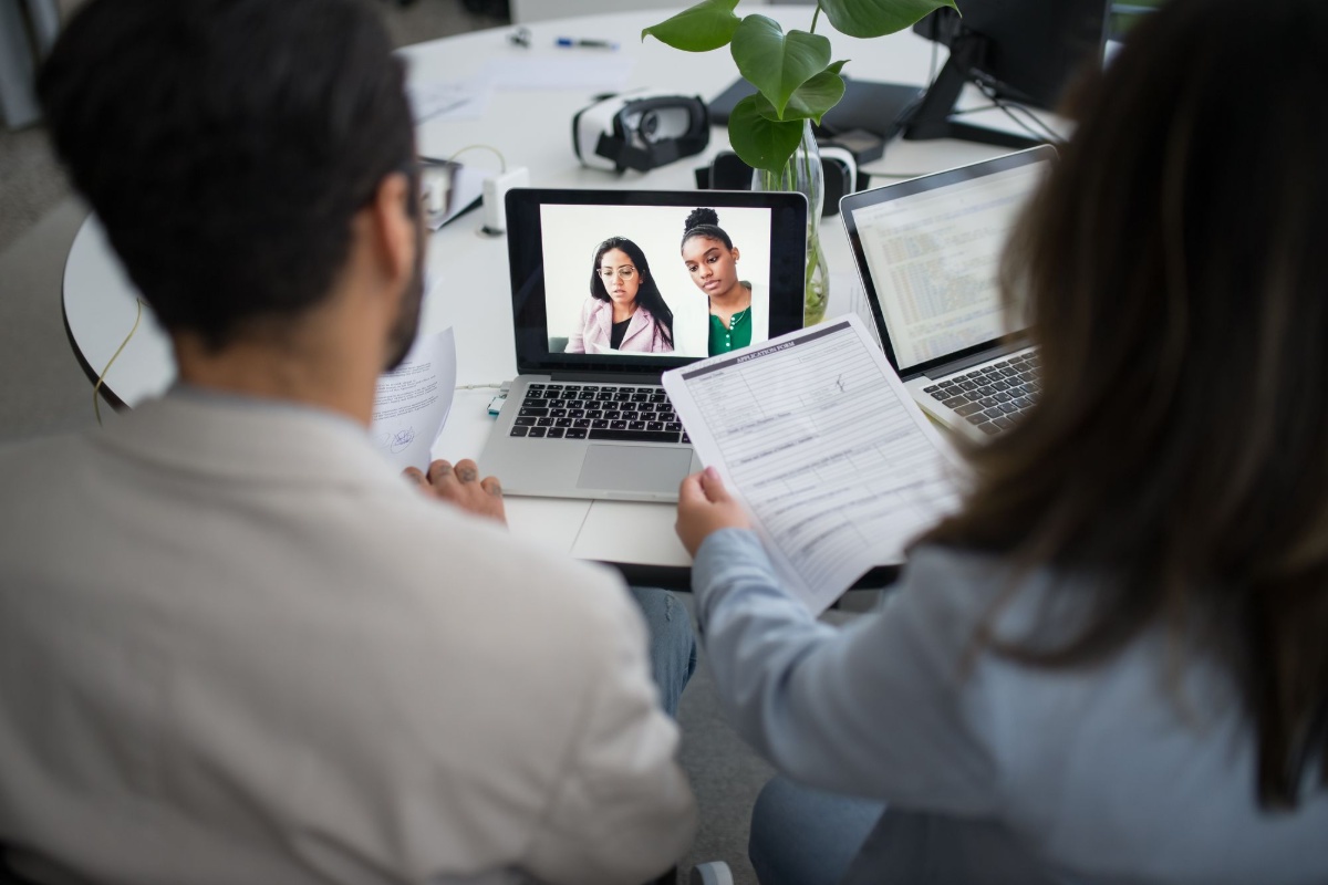 Professionals conducting an online job interview using a laptop