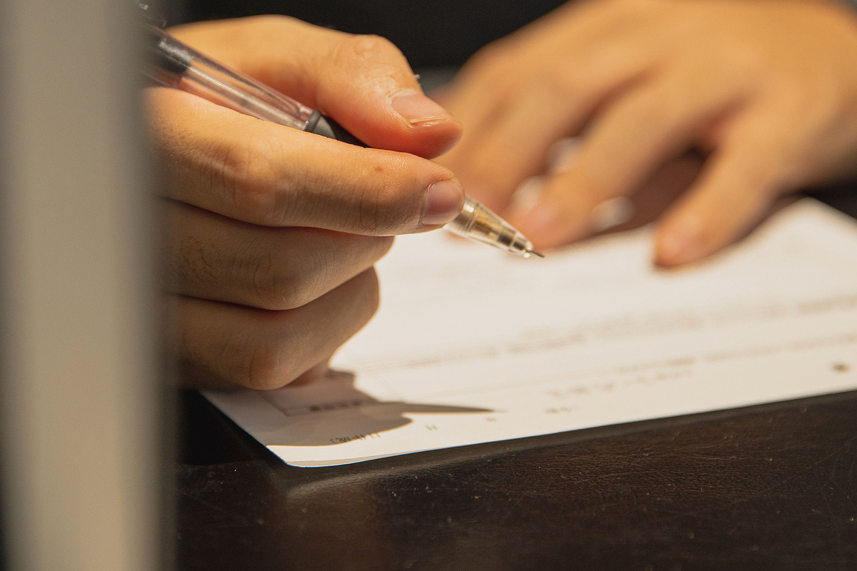 Person carefully completing financial application paperwork