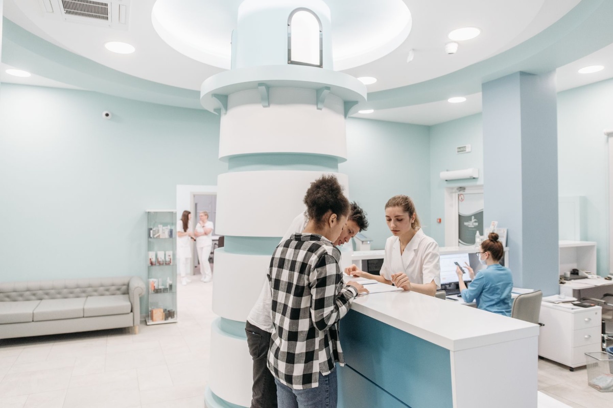 Patients checking in at a clinic reception under public health insurance