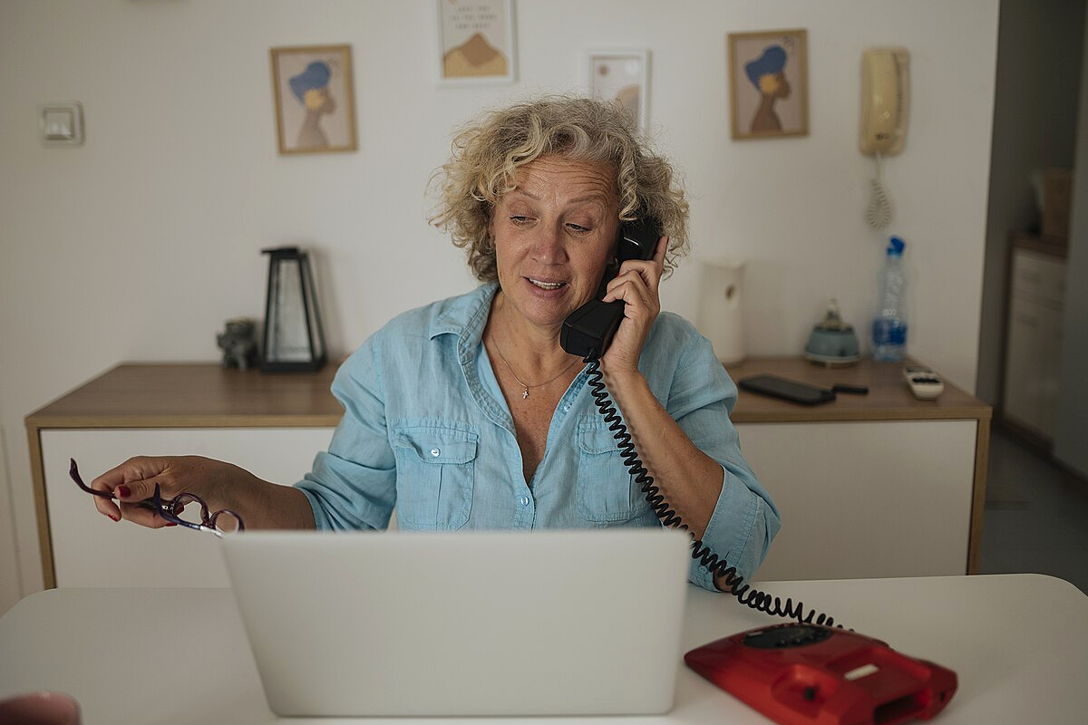 Resident confirming certificate requirements by phone while taking notes