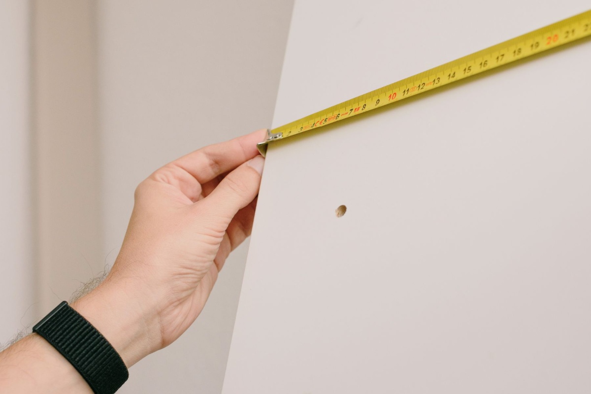 Measuring an existing mark on an apartment wall during move-in inspection