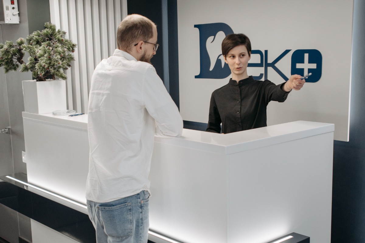 Patient checking in with a receptionist at a dental clinic