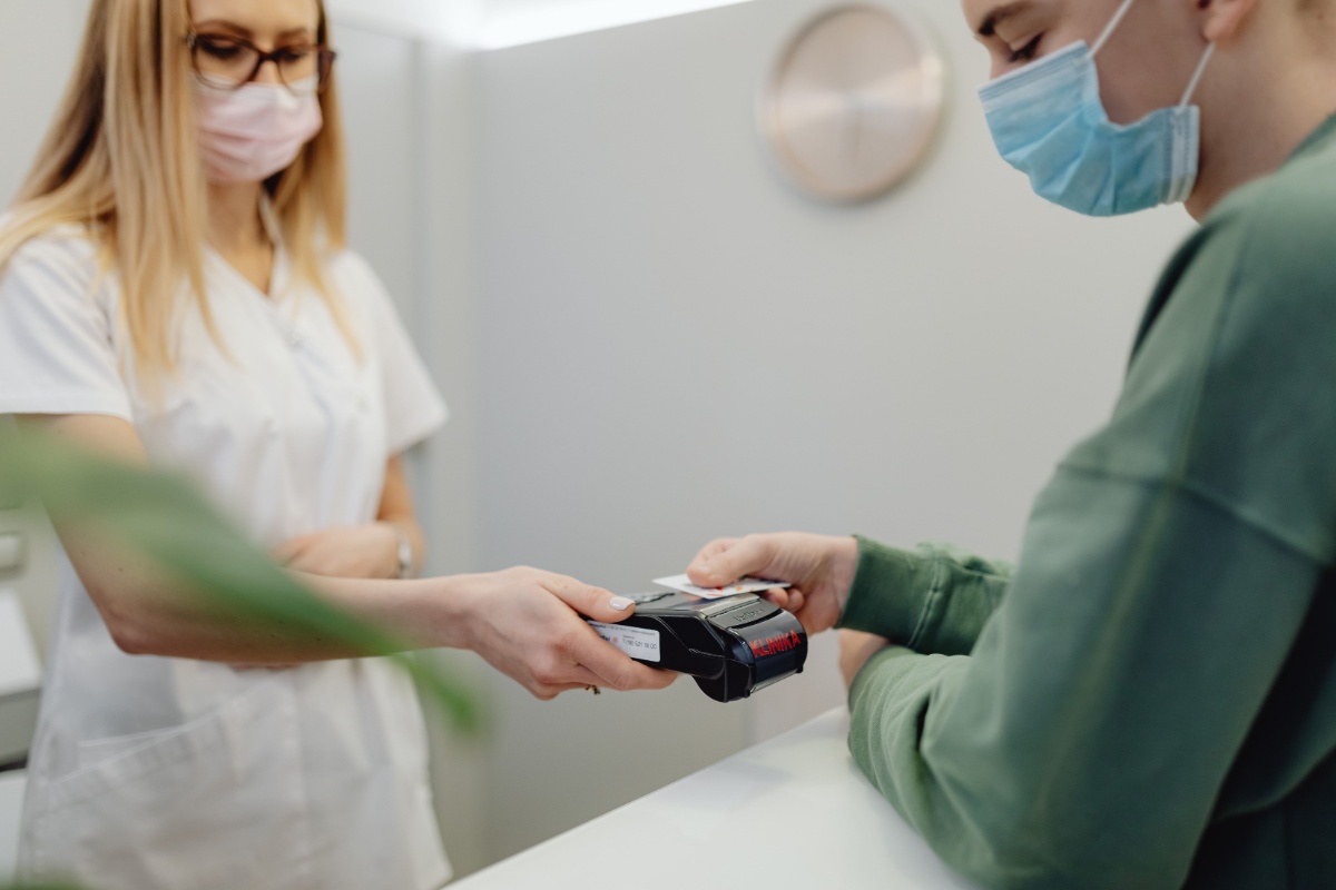 Patient paying at a clinic reception counter after treatment