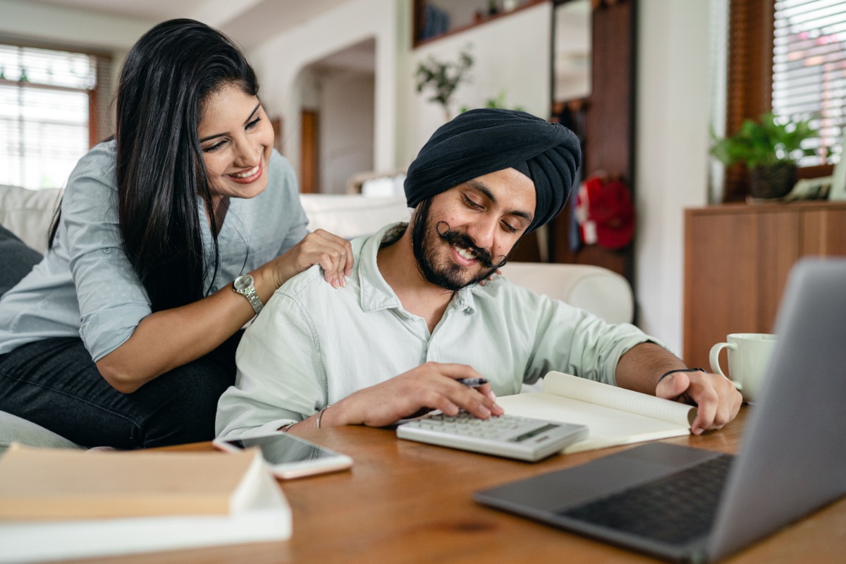 Residents preparing annual finances together at home with a laptop and calculator