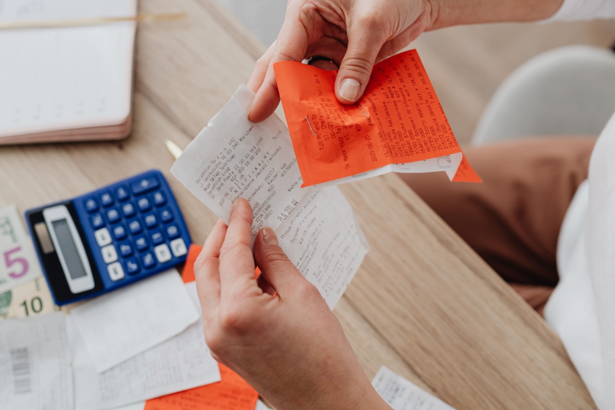 Hands sorting receipts and financial records before filing taxes