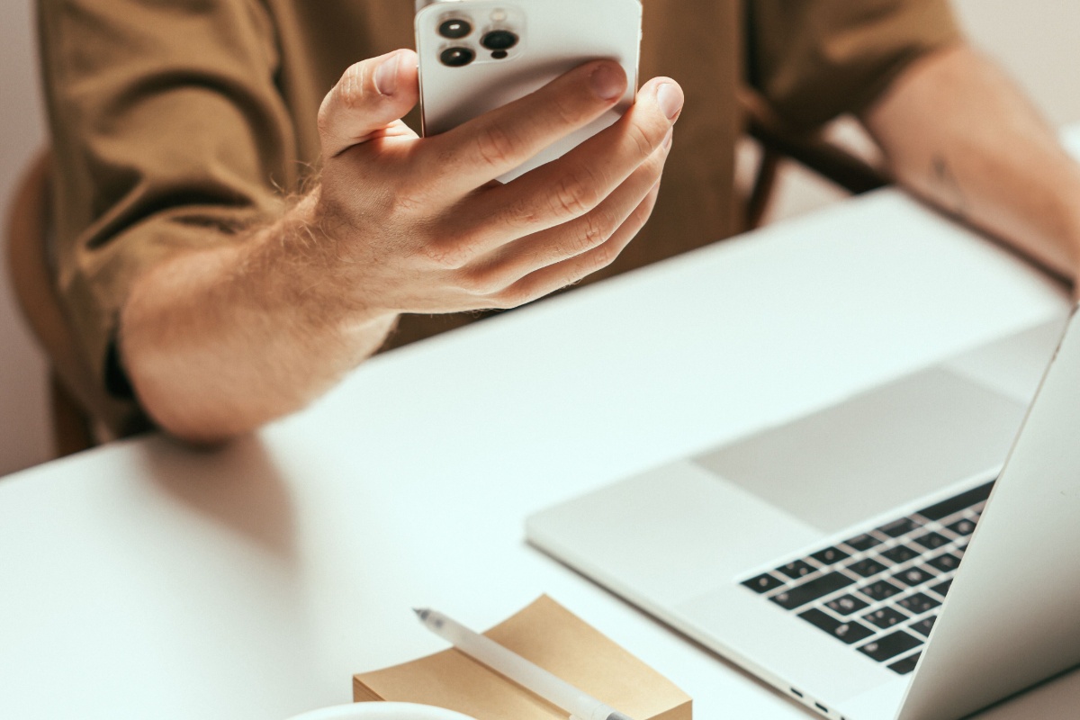 Resident using a smartphone beside a laptop after electronic tax filing