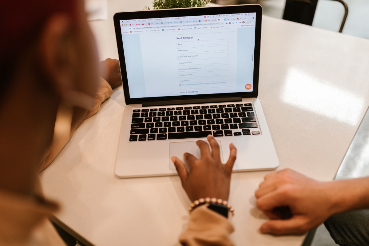Person completing an online notification form on a laptop