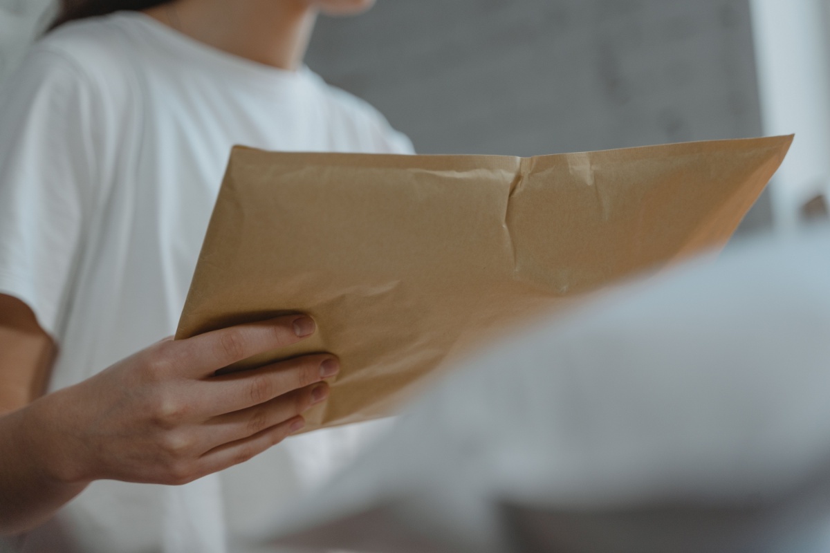 Person holding a document envelope for postal submission