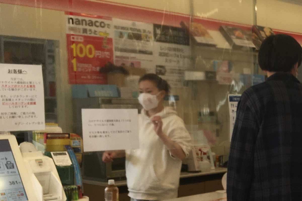Customer at a Japanese convenience-store register during a payment transaction