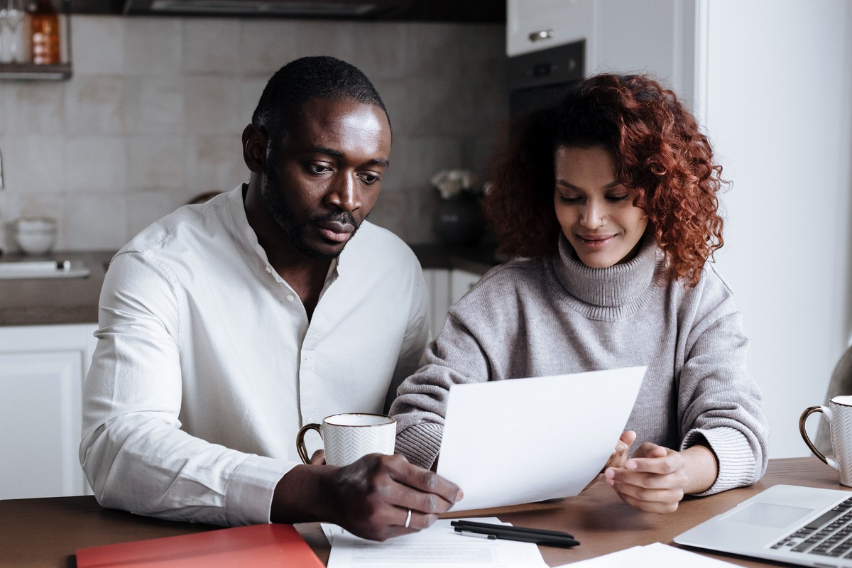 Married couple reviewing spouse visa application documents at home