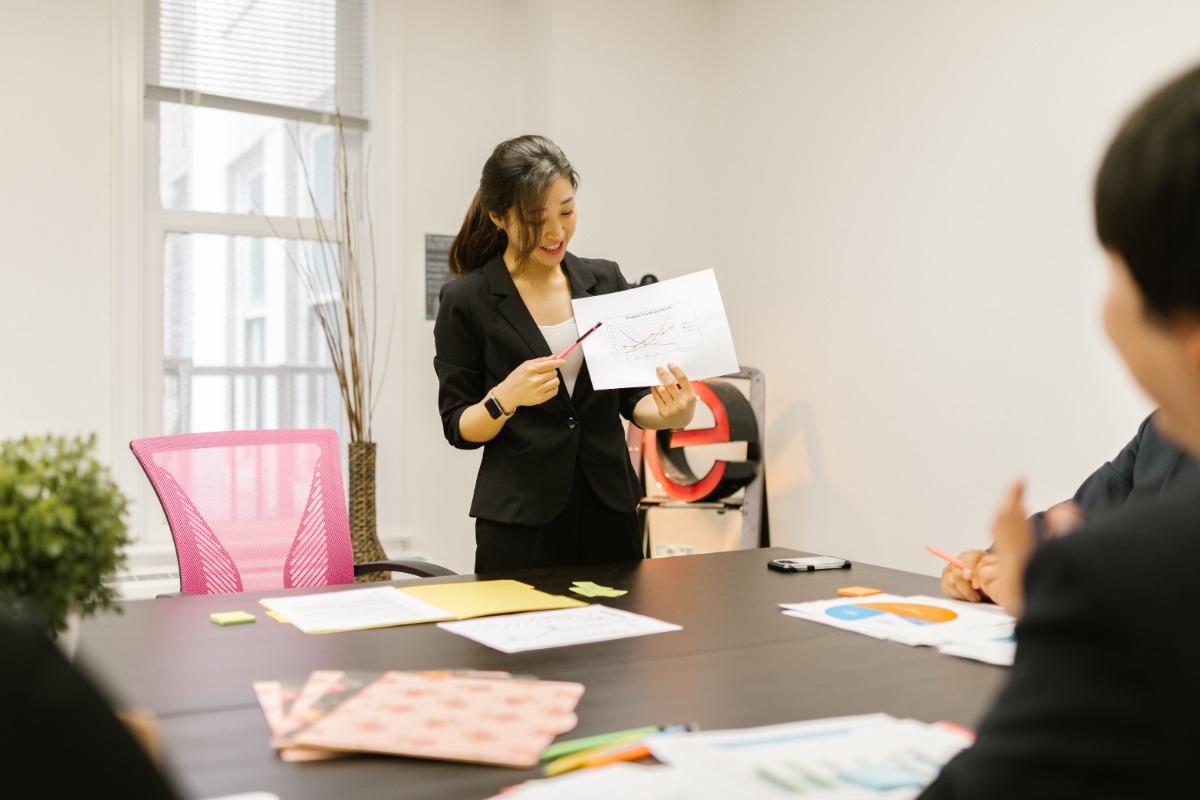 Japanese professional presenting a chart to colleagues