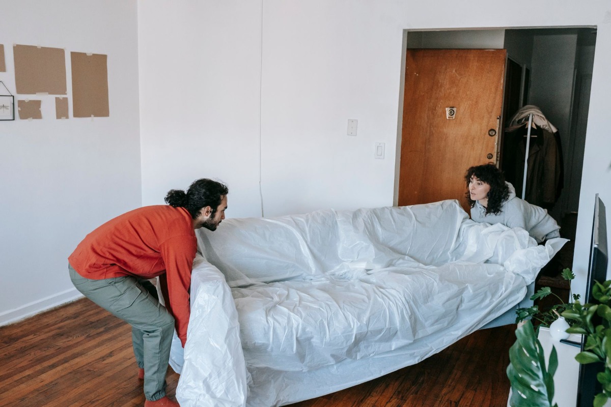 Couple moving a sofa into an apartment
