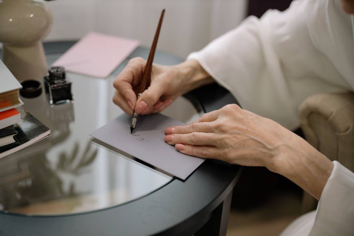 Person writing an address on an envelope