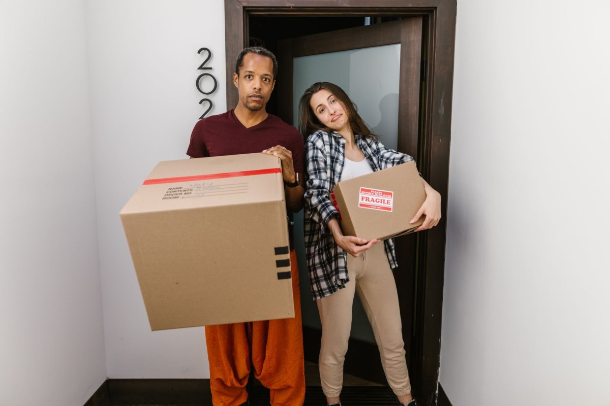 Couple moving boxes into a new apartment