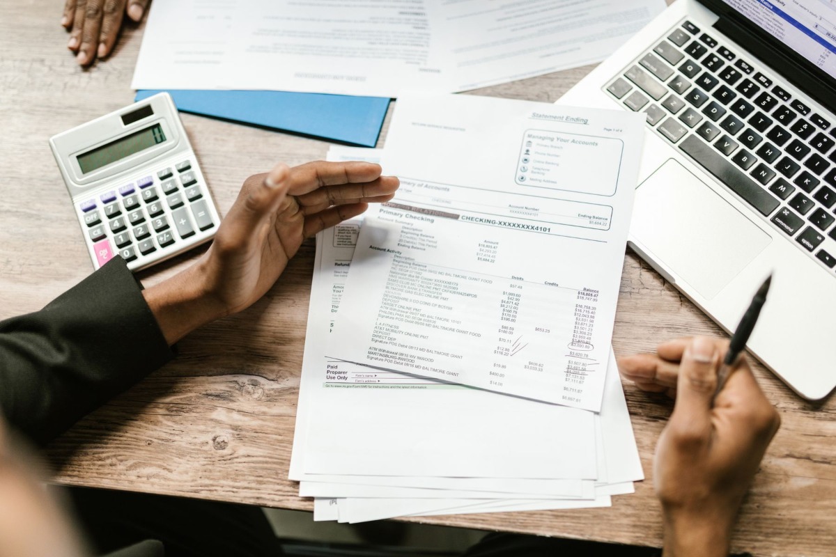 Financial documents and calculator used to check payroll deductions