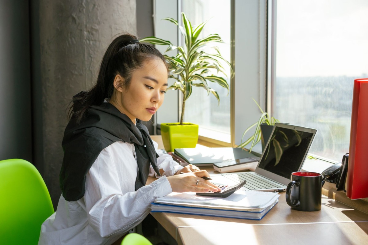 Office worker reviewing salary documents with a calculator