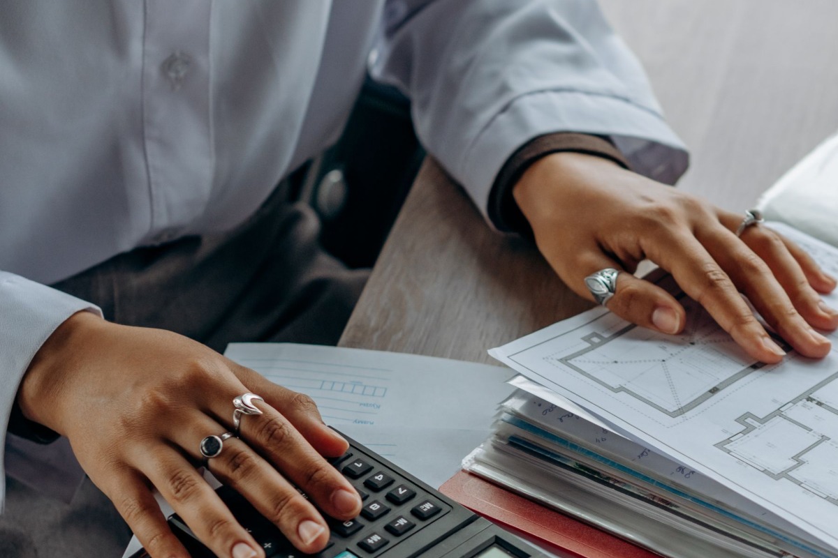Person checking payroll figures with a calculator and documents