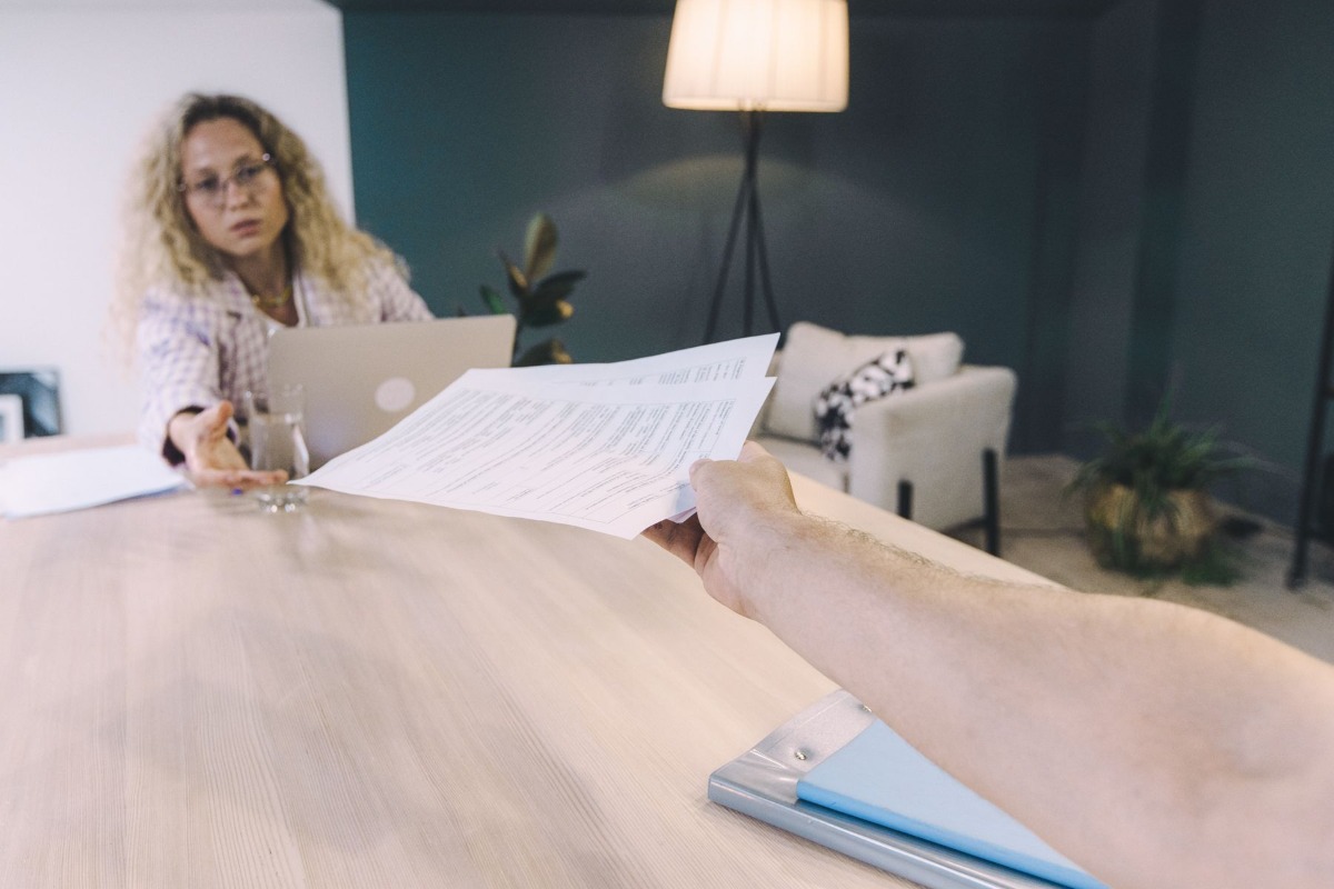 Professional handing official documents across an office desk