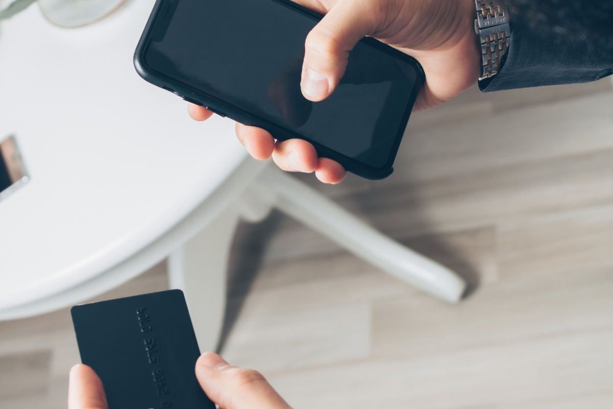 Person using a smartphone and bank card for digital banking