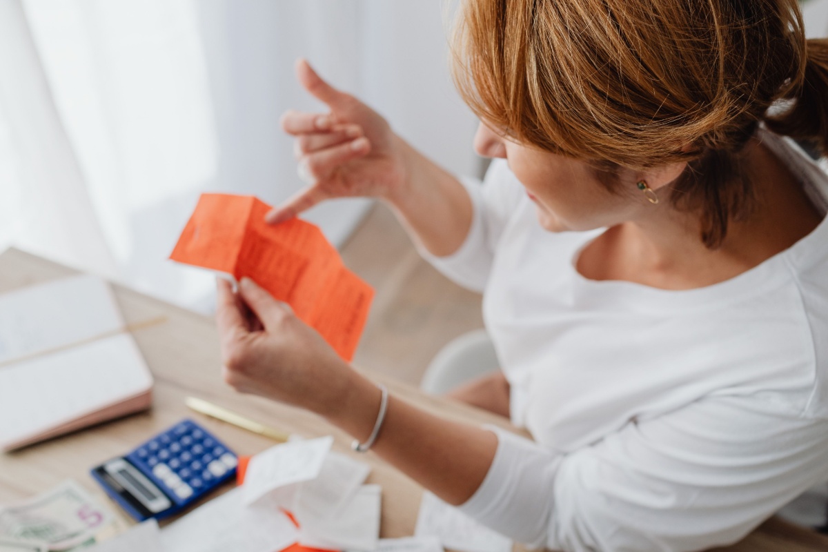 Person reviewing receipts and banking costs at a laptop
