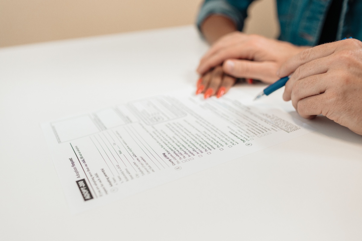 Hands completing application documents for a family benefit
