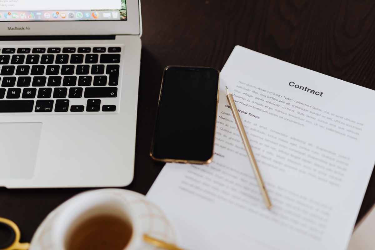 Rental contract and digital devices on a desk before signing