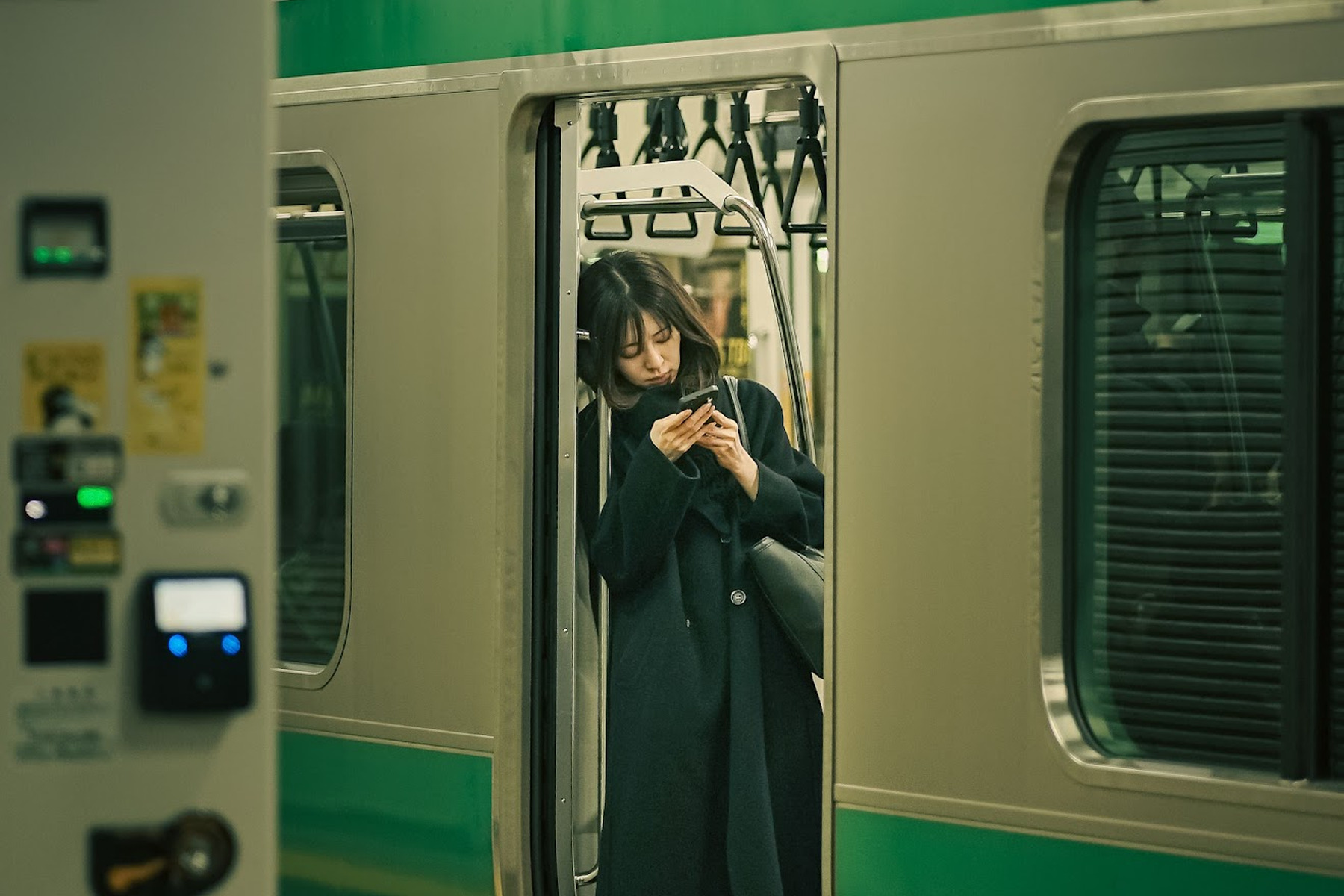 Commuter using a smartphone on a Tokyo train